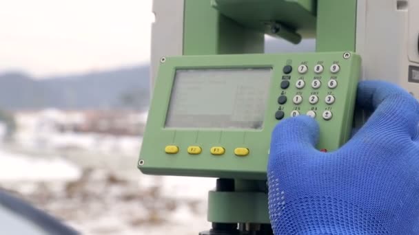 Närbild-finger som driver knapparna Surveyor på jobbet mäta avstånd. Begreppet vinter konstruktion — Stockvideo