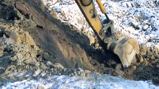 Wnter konstruktion. Närbild av en hink grävmaskin väcker marken. Begreppet konstruktion. — Stockvideo