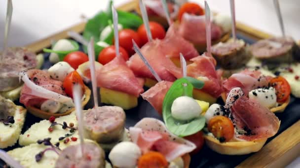 Feche a mesa do buffet. Sanduíches com salsicha, tomate e mussarela. Deliciosos petiscos na mesa do banquete — Vídeo de Stock