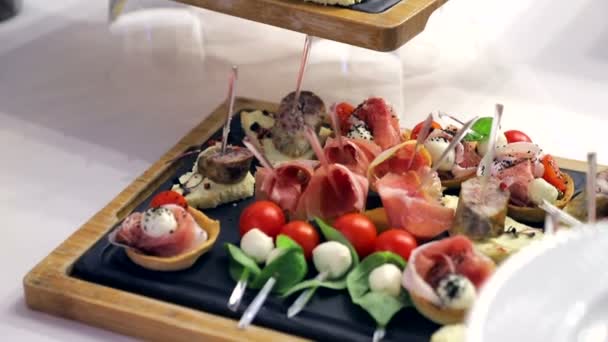 Mesa Buffet. Sandwiches con salchicha, tomate y mozzarella. Deliciosos aperitivos en la mesa del banquete — Vídeos de Stock