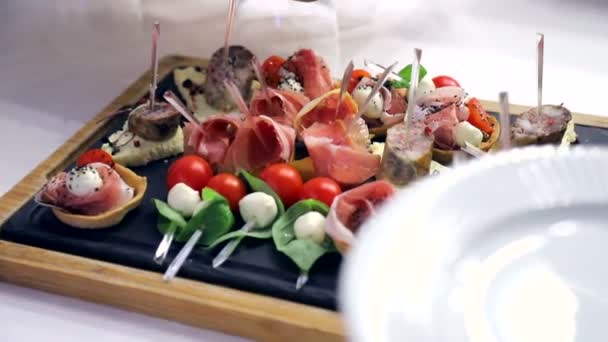 Mesa Buffet. Sandwiches con salchicha, tomate y mozzarella. Deliciosos aperitivos en la mesa del banquete — Vídeo de stock