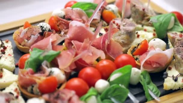 Sandwich Canapes auf dem Buffet-Tisch. rote Tomaten mit Mozzarella-Käse mit Kräutern und Wurst mit Brot — Stockvideo