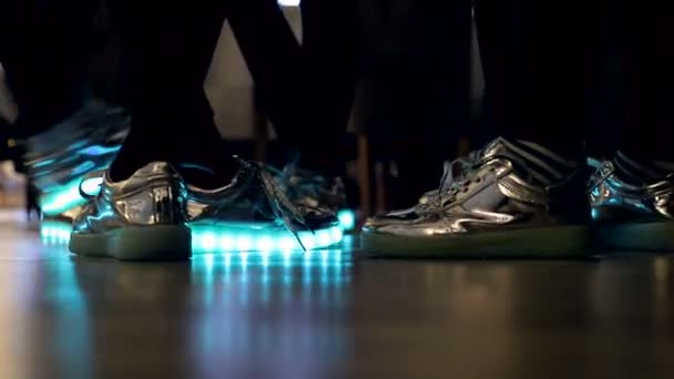 Крупный план светящихся и сверкающих ботинок на ногах девочек, светло-голубой — стоковое видео