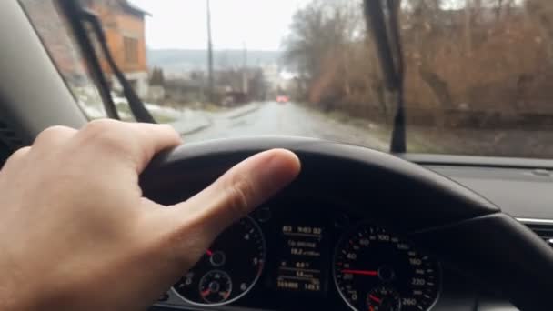Närbild-arm som håller ratten i en bil. Dynamisk rörelse av bilen på en molnig dag. Kameran skakar och upprepar förslaget bilar i depån — Stockvideo