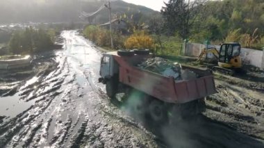 İnşaat enkaz ile yüklenen kamaz kamyon bataklığa gider. Şantiye yağmur sonra.