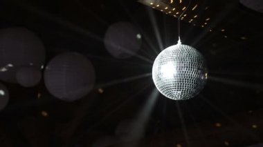 Disko topu yansıtan ışık ışınları duman aydınlatmak. Disko topu eğirme sorunsuz ile siyah arka plan üzerinde fişekleri.