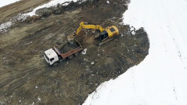 UCRANIA LVIV 29 de diciembre de 2018. La excavadora de vista aérea carga el camión con el suelo. Limpiando el sitio de construcción. Pantano en la obra — Vídeos de Stock