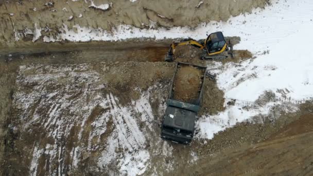 UKRAINE LVIV December 29th 2018. Aerial view excavator loads the truck with the ground. Clearing the construction site. Swamp on the construction site — Stock Video