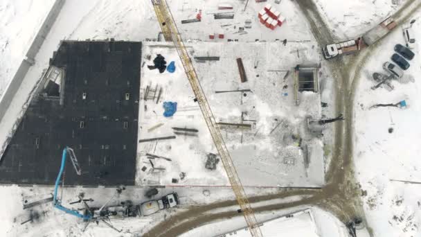 Aerial Work of a building crane, a view from above. Cement filling with a special crane. Winter construction — Stock Video