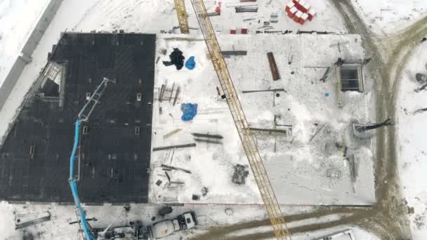 Luchtfoto werk van de kraan van een gebouw, een weergave van bovenaf. Cement vullen met een speciale kraan. Winter bouw — Stockvideo