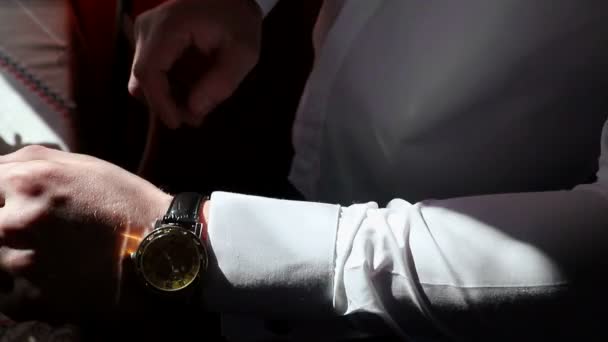 Ein junger Geschäftsmann trägt eine teure goldene Uhr am Arm. Blick auf die Uhr und verdeckt seine Hand. — Stockvideo