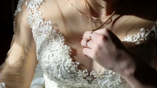 Bellissime spose corpo. La sposa è in piedi vicino alla finestra, i raggi del sole cadono sul suo corpo. La sposa tiene la mano vicino al petto . — Video Stock