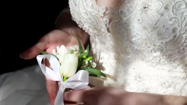 Gelin bir çiçek yaka çiçeği elinde tutan ve gösterir. Gelinler vücut ve çiçek üzerinde güneş ışınlarının düşme