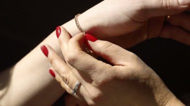 Altın zincir bir womans elde. Kız bir altın takı kızlar el tutturmak için yardımcı olur