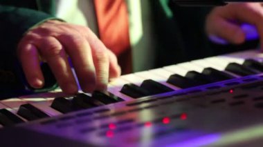 elektronik bir synthesizer oynayan yaşlı bir adamın parmak