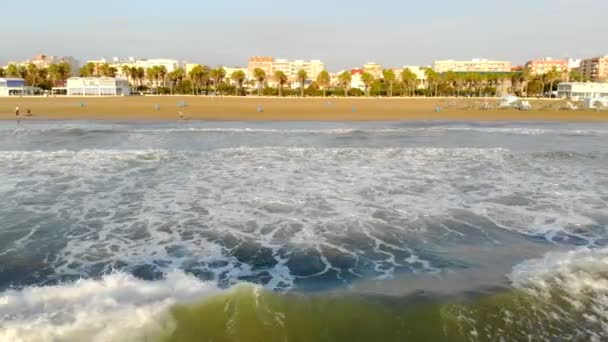 Volo basso sulle onde che arrivano a riva. L'onda sotto l'ombra forma una grande quantità di schiuma e bolle. Aerea Spagna, Mar Mediterraneo — Video Stock