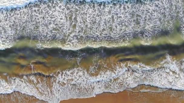 Luftaufnahme vom Strand von Spanien, wo die Wellen ans Ufer kommen und vor der Küste Schaum und Blasen bilden. das Aussehen eines Drons. Hintergrund oder Textur — Stockvideo
