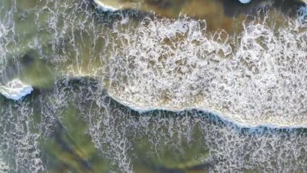 Вид з повітря на пляж Іспанії Хвилі виходять на берег і утворюють піну і бульбашки біля узбережжя. Погляд на дрон. Тло або текстура — стокове відео