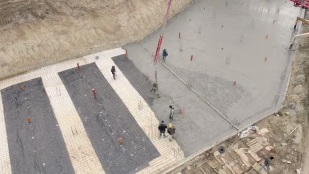 Aerial Workers work on the construction site. The process of pouring concrete foundations of the future home — Stock Video