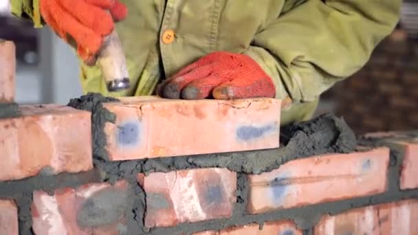 Colocação de tijolos. Mãos que colocam um tijolo em um canteiro de obras — Vídeo de Stock