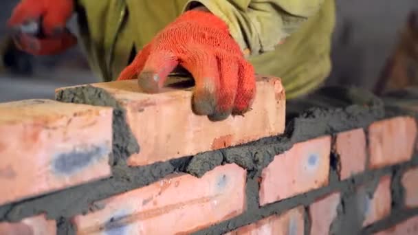 Bricklaying. Hands that put a brick on a construction site — Stock Video