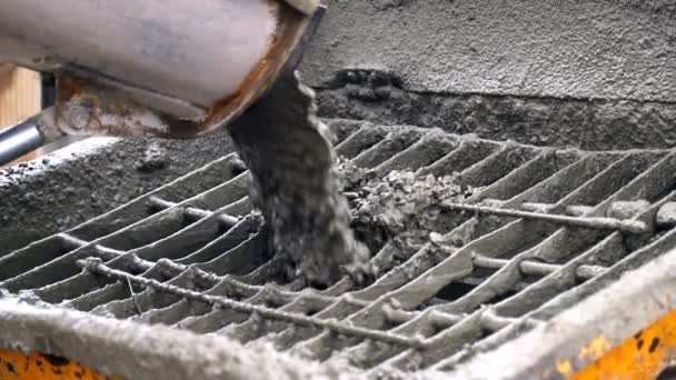 Бетон из бетонного смесителя попадает в бетонный податчик. Крупный план бетонных частиц, движущихся медленно — стоковое видео