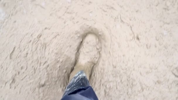 Le marais sur un chantier. Les pieds des hommes en bottes en caoutchouc sont dans le marais. Itinéraire difficile — Video