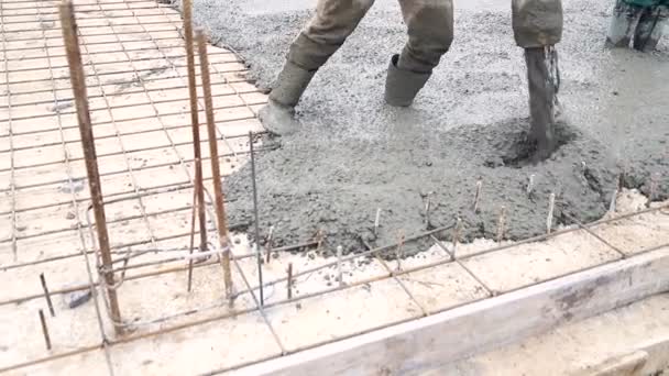 Hälla betong blanda från cementblandare på betong formsättning. En grupp av arbetstagare hälla betong på en byggarbetsplats — Stockvideo