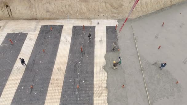 Luchtfoto werknemers werken op de bouwplaats. Het proces van gieten concrete grondslagen van de toekomstige woning — Stockvideo