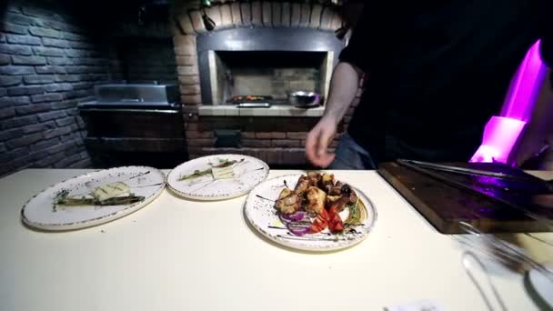 Шеф-повар поливает соусом и приправляет кусочки готового кебаба — стоковое видео