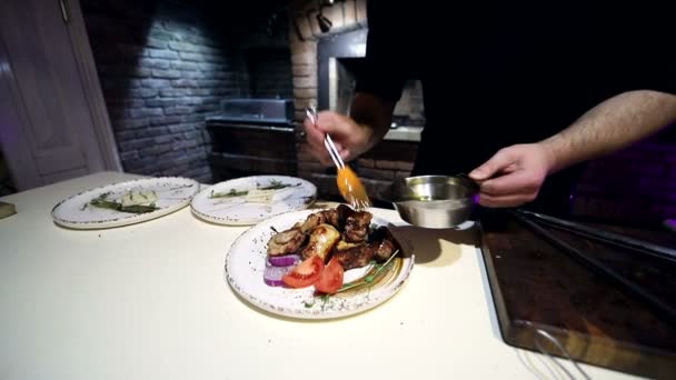Chef regar la salsa y condimentar los pedazos del kebab terminado — Vídeos de Stock