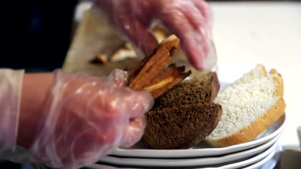 El camarero en los guantes de pone el pan en el plato, y lo prepara para la entrega . — Vídeos de Stock