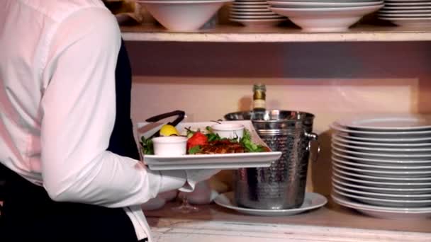 Kyparen håller restauranger specialitet i sin hand. Sätter på en tallrik bredvid skålen metall viskningar för överliggande mat — Stockvideo