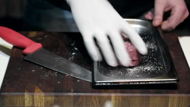 シェフは肉の生の作品にスパイスを振りかけます。揚げる前に肉のマリネの調製 — ストック動画
