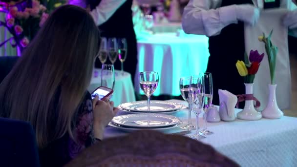 La mujer en el restaurante trabaja con un teléfono móvil. Juventud moderna con gadgets en lugares públicos — Vídeo de stock