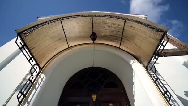 Una pequeña iglesia vieja, y al lado de tui alto que revolotean del viento — Vídeo de stock