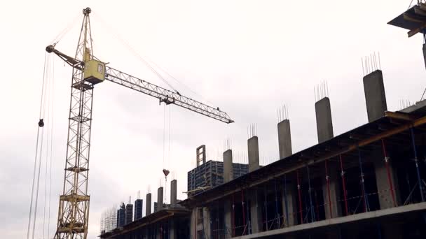 Staveniště se pracovníci a stavební jeřáb — Stock video