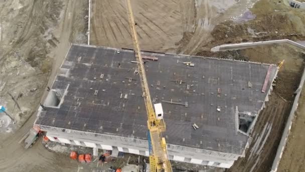 Construcción de un edificio de gran altura, una vista desde la parte superior con un dron. Los trabajadores construyen una casa. Panorama desde la parte superior de la obra — Vídeos de Stock