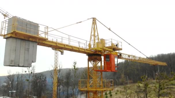 Letecký pohled na velkou stavební jeřáb, zblízka. Stavební jeřáb na pozadí budovy, zblízka. — Stock video