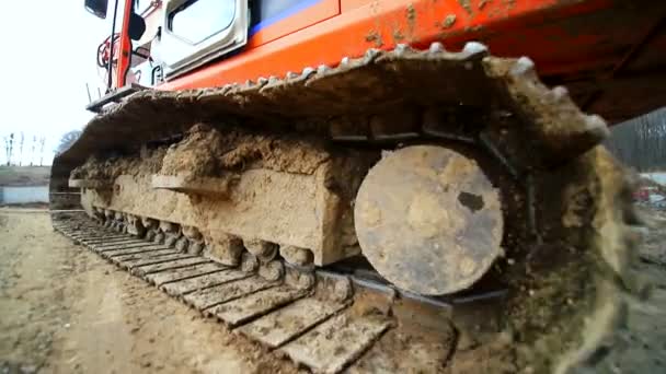 Close-up van een caterpillar crawler die in een moeras rijdt. Geschoten door groothoeklens. Slow motion — Stockvideo