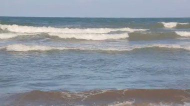 Dalga kıyıya, su güneş parlar yakın geliyor. Dalga deniz tarafından beyaz kum sahil güzel yıkanır. Arka plan veya doku