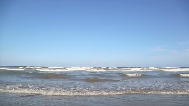 Onda chega perto da costa, o sol brilha na água. A onda do mar é lavada pela pitoresca costa de areia branca. Contexto ou textura — Vídeo de Stock