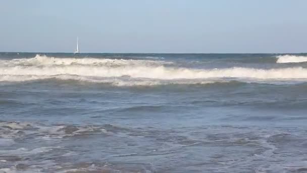 波は水に太陽が輝いて、海岸の近くに来ない。海の波は、白い砂浜の美しい海岸に洗われます。背景やテクスチャ — ストック動画