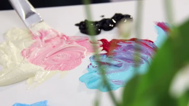 Der Künstler mischt Pinsel in Elfenbein und rote Farbpalette für das Mischen von Farben. Vorbereitung auf die Ziehung — Stockvideo