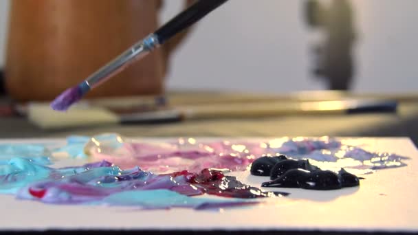 Artista mistura cores diferentes de tinta acrílica com uma escova para desenho. Preparação de cores para desenhar quadros — Vídeo de Stock