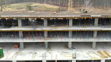 Inşaat sürecinde binanın havadan çekimi. İşçiler çatıya çimento dökme için bir platform hazırlamak.