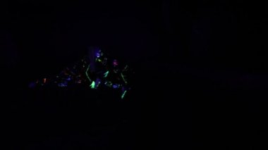 Neon ışıkta çocuklar, floresan makyaj ile kız, UV ışığında dans kadın disko dansçı sanat tasarımı, renkli makyaj. Yavaş hareket