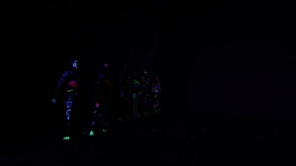 Děti v neonové světelné, dívky s fluorescenčním make-up, výtvarné návrhy ženského disco tanečnice tančí v UV světle, barevný make-up. Zpomaleně — Stock video
