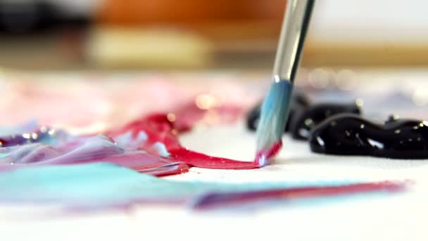 Artist mixes different colors of acrylic paint with a brush for drawing. Preparation of colors for drawing pictures — Stock Video