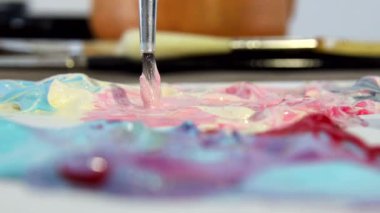 Sanatçı farklı renklerde akrilik boya çizim için bir fırça ile karışımları. Resim çizmek için renkleri hazırlanması